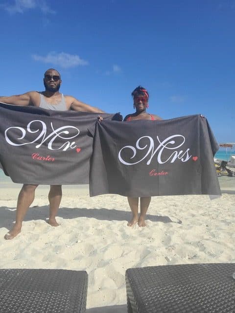 happy black couple at the beach wearing towel