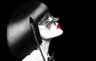 Sexy woman in mask holding whip at night, selective coloring. BDSM. Mask and tux outfit with red lips and cleopatra hair style.