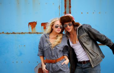 Attractive adventurous couple, with blue grunge metal wall background