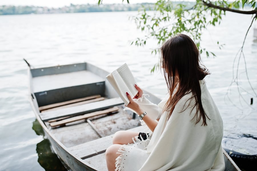 woman reading a book in a boat 