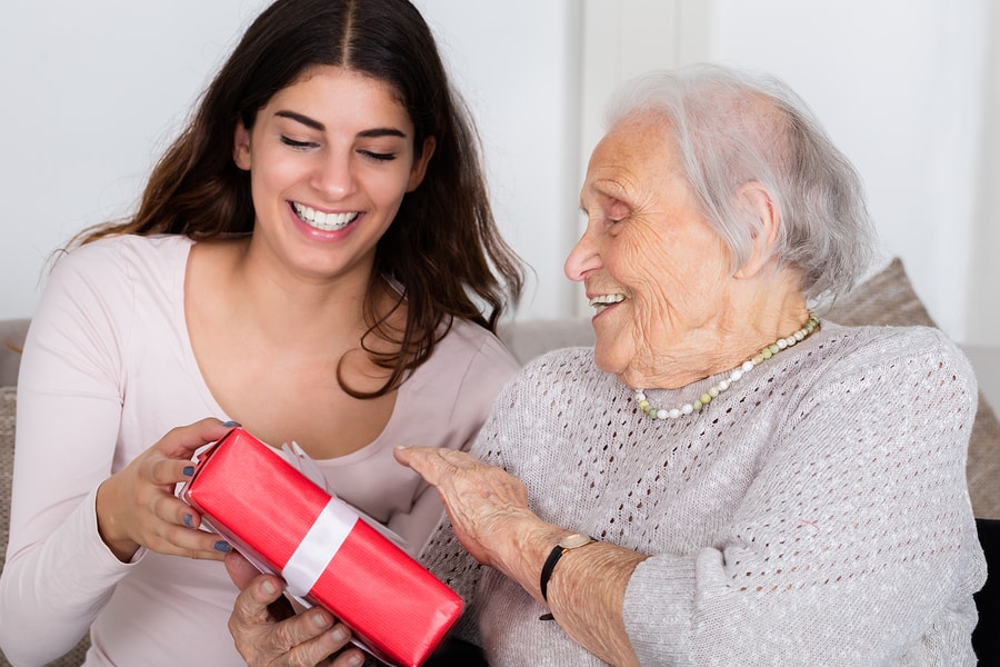 Happy Grandmother receiving Gift from Her Granddaughter