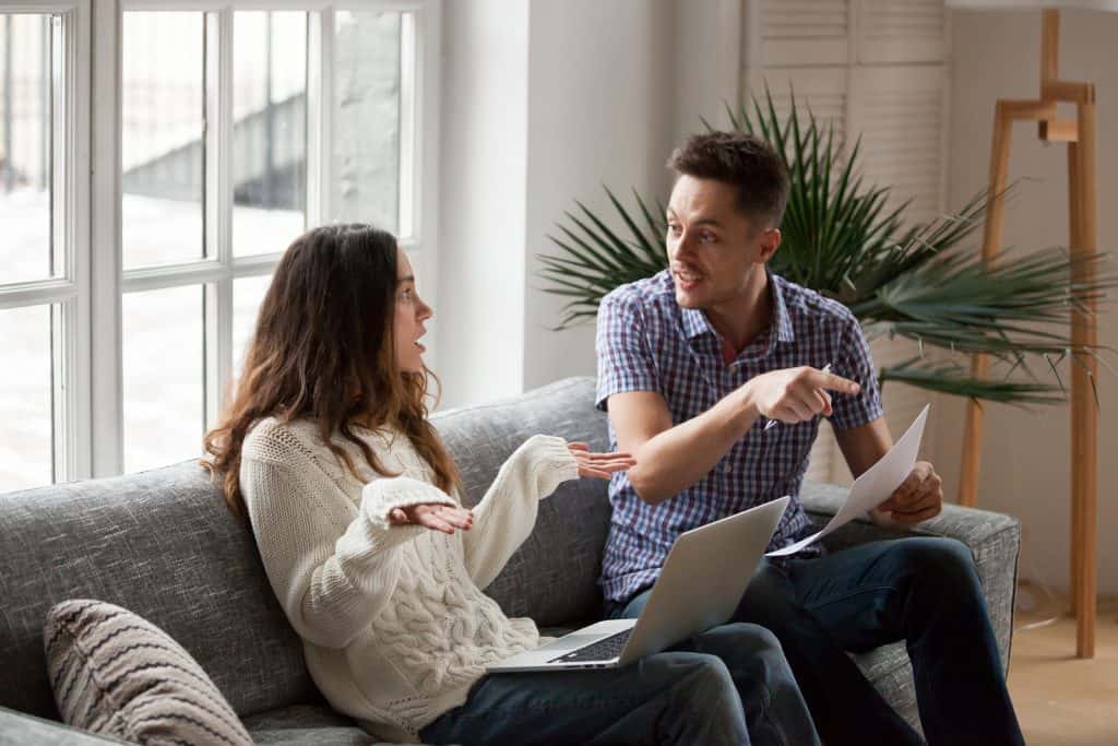 young couple bickering over bills