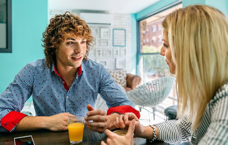 Young man and woman drinking something at a cafe