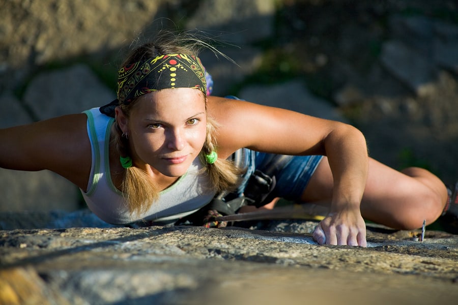 blonde lady climbing on the rock