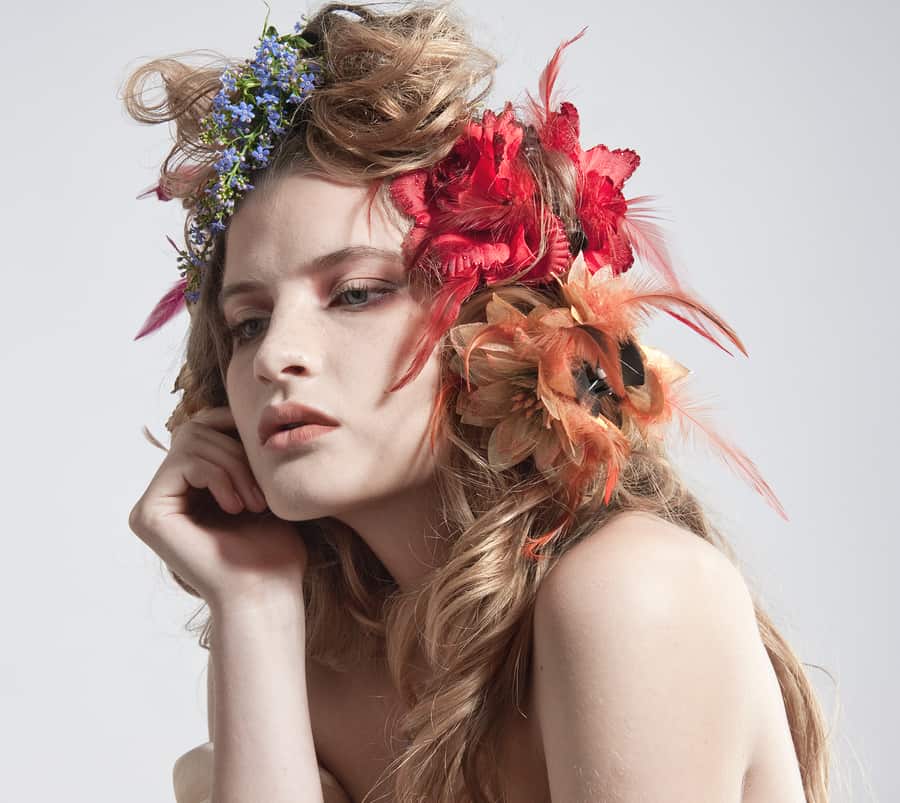 Face of a beautiful woman with summer flowers in her hair